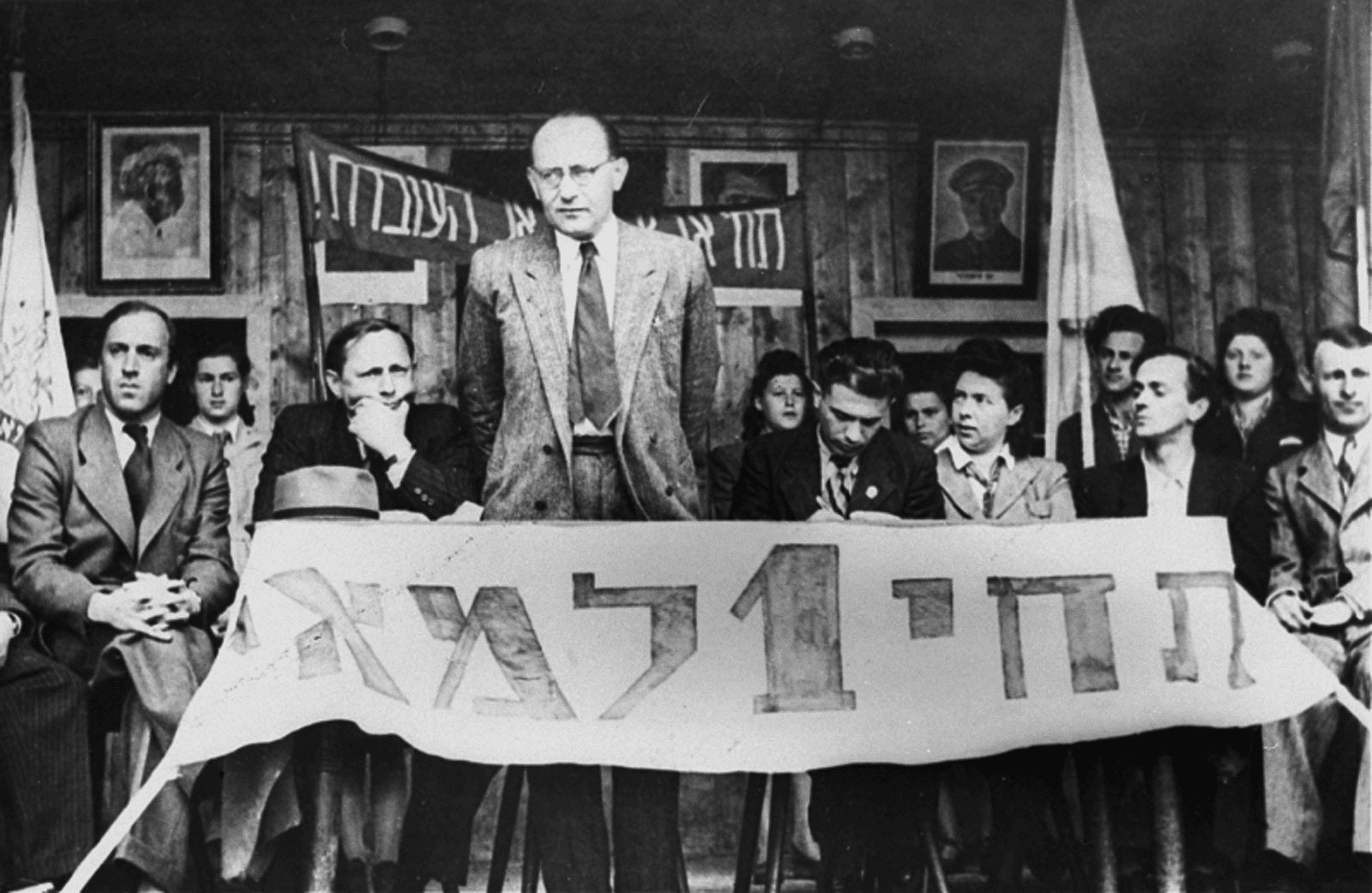 1. Mai, Feiertag der Arbeiter: Chaim Yahil als Vertreter der Jewish Agency mit Überlebenden der NS-Verfolgung („Displaced Persons“) im DP-Camp München-Neu-Freimann (1946 / 1948). Die Jewish Agency organisierte die Einwanderung nach Palästina.  Foto: Jack Sutin / United States Holocaust Memorial Museum, courtesy of Saul Sorrin